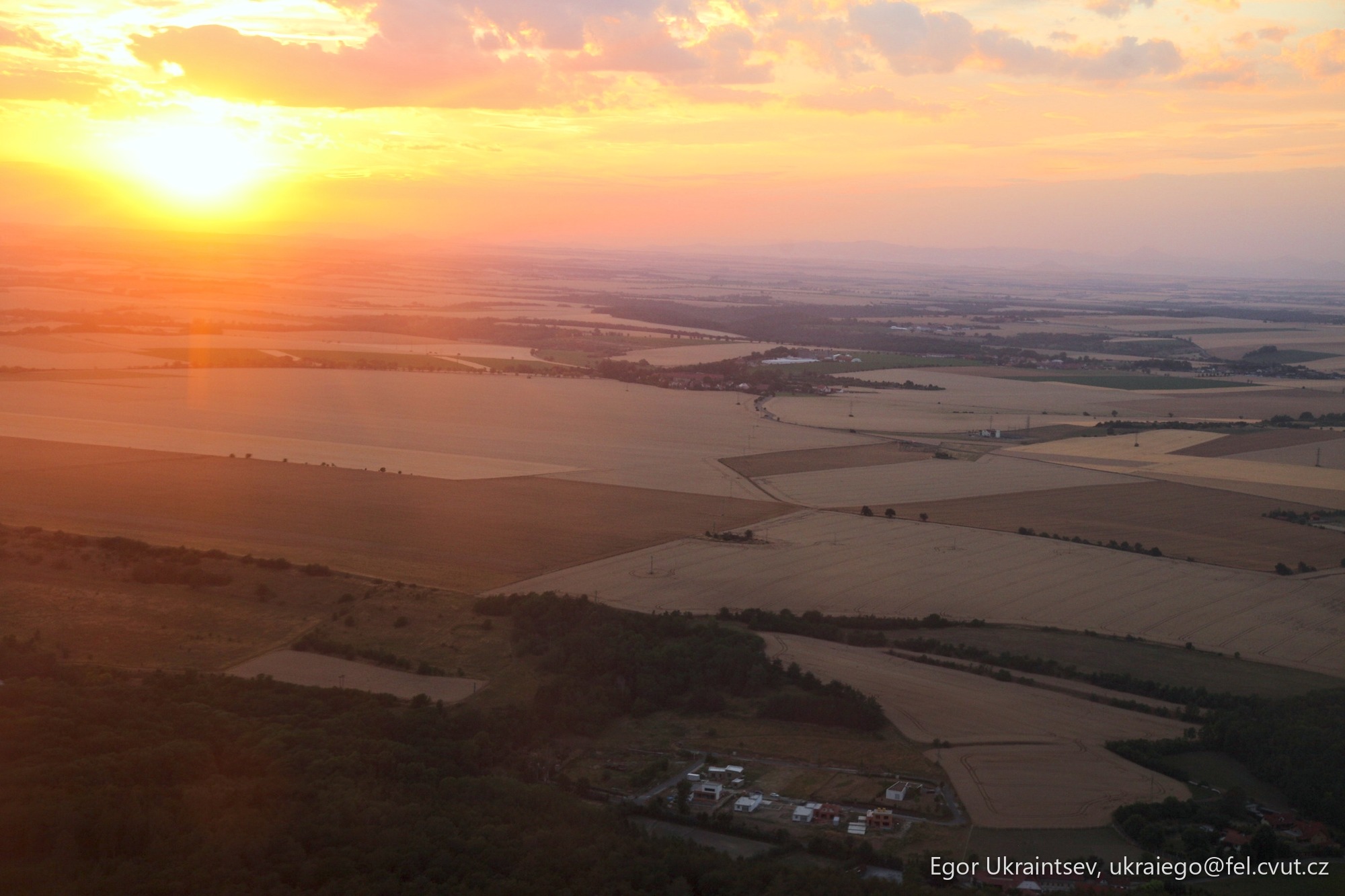 Sun setting over farmland fields