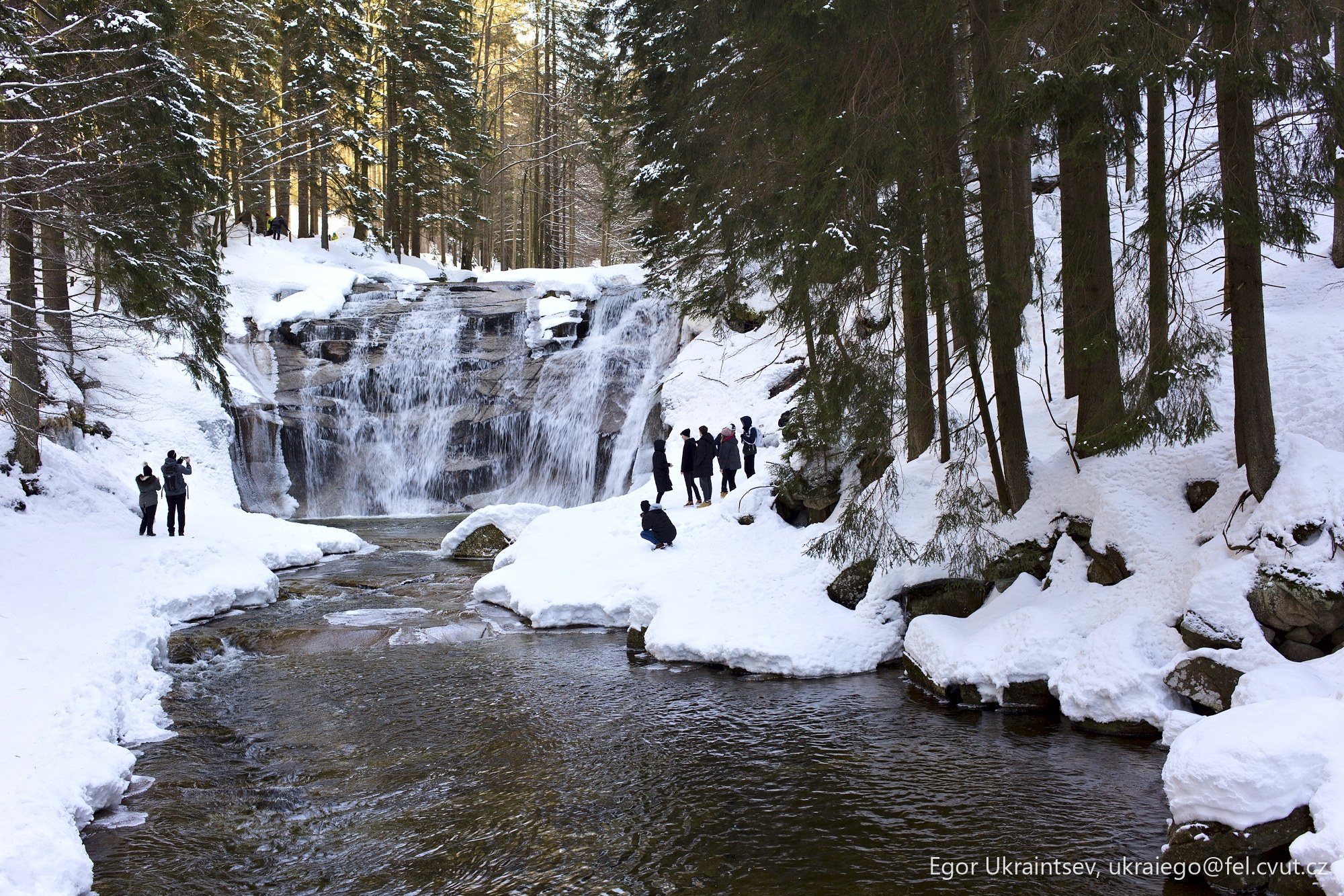 People standing by a waterfall