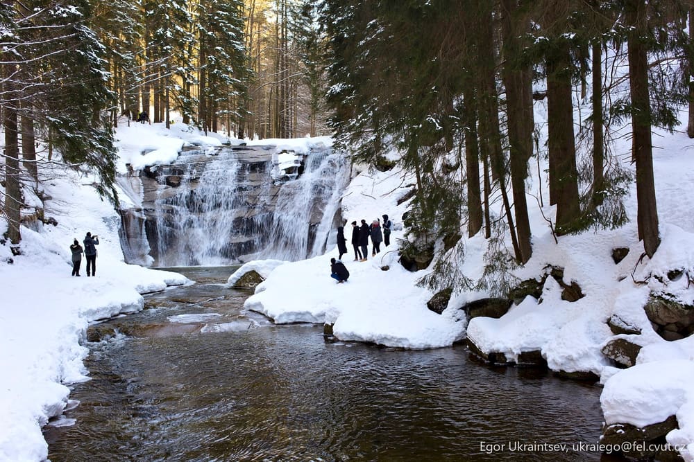 People standing by a waterfall