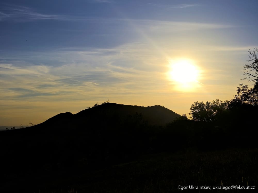 Sun setting behind a hill