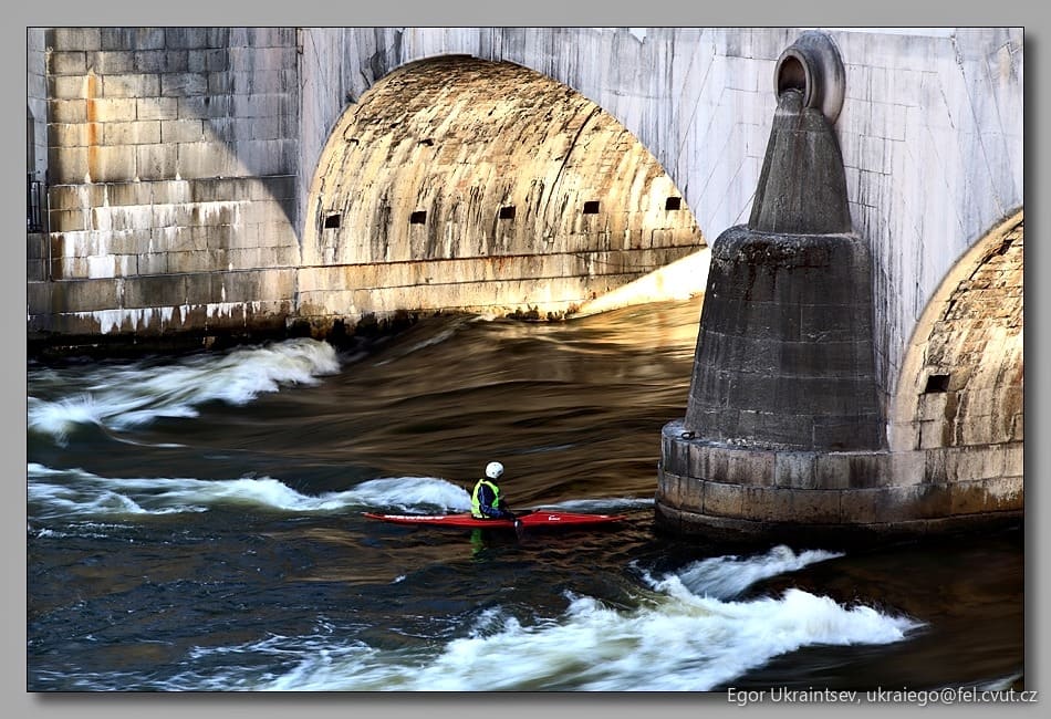 Man paddling under a bridge